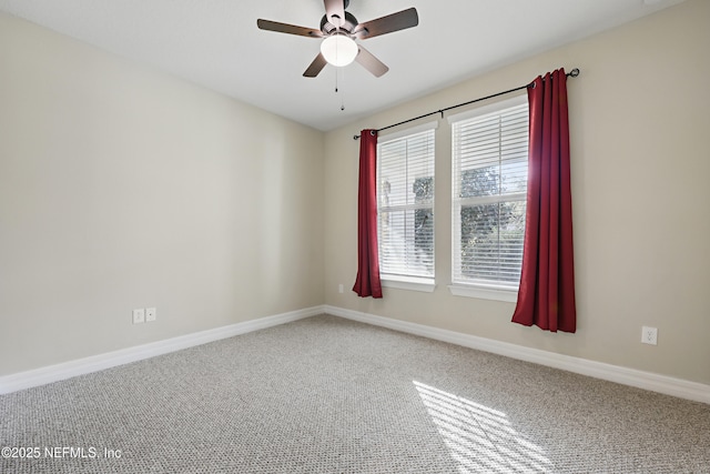 empty room with carpet, a ceiling fan, and baseboards