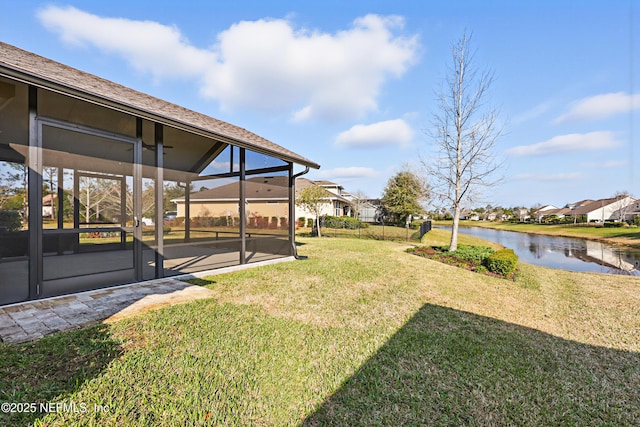 view of yard featuring a water view and glass enclosure