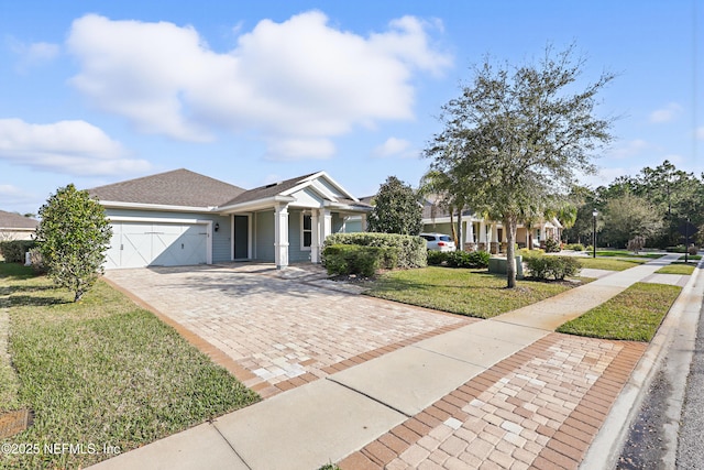 view of front of home with a garage, decorative driveway, and a front yard