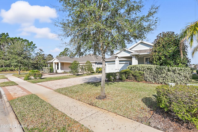 view of front facade with a garage, decorative driveway, and a front yard