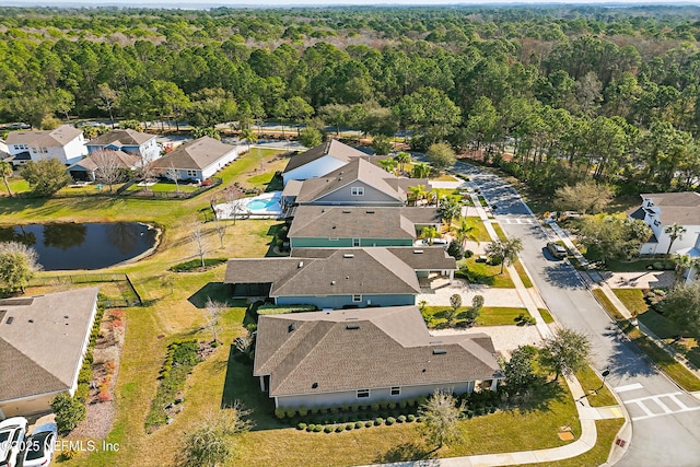 drone / aerial view featuring a residential view and a wooded view