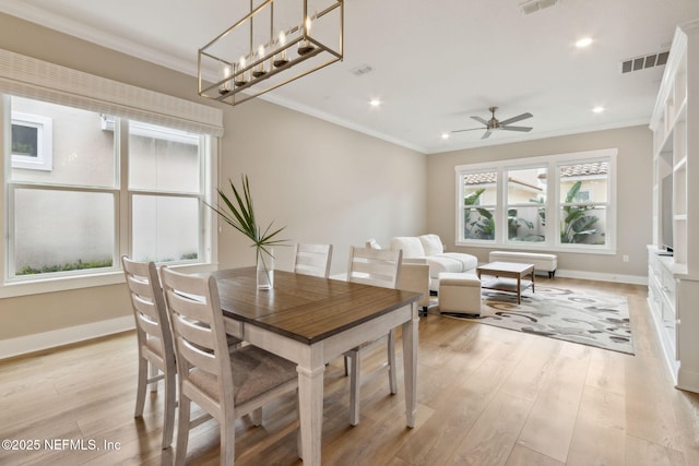 dining space featuring light wood-type flooring, plenty of natural light, and crown molding