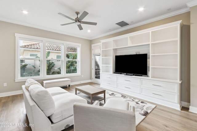 living area with ornamental molding, light wood-style flooring, visible vents, and baseboards