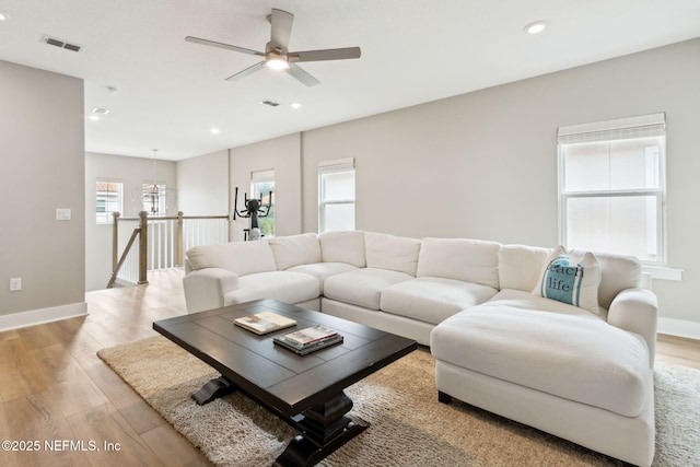 living room featuring baseboards, light wood finished floors, visible vents, and recessed lighting