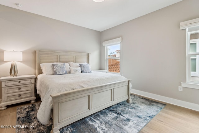 bedroom with baseboards and wood finished floors