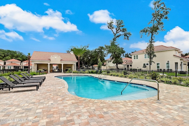 pool featuring a residential view, fence, and a patio