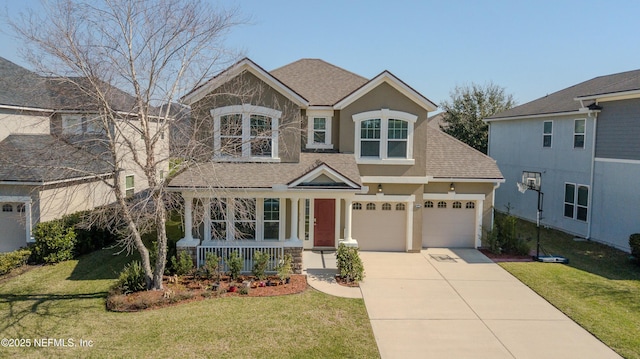 view of front of house featuring roof with shingles, covered porch, a front yard, a garage, and driveway