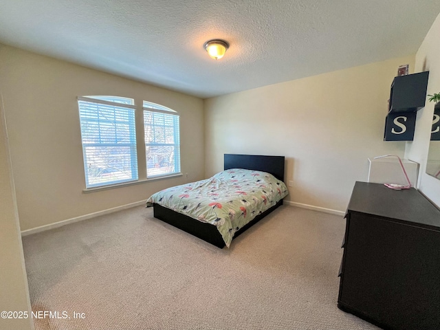 bedroom featuring carpet, baseboards, and a textured ceiling