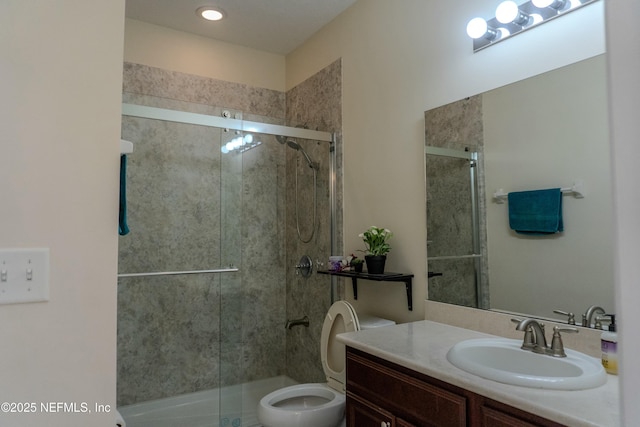 bathroom with toilet, a shower stall, and vanity