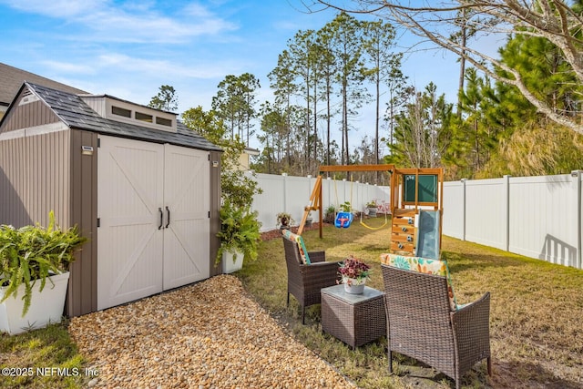 95170 Timberlake Dr, Fernandina Beach, FL 32034 - view of yard featuring an outbuilding, a playground, a fenced backyard, and a storage unit