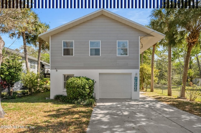 view of side of home featuring a garage, concrete driveway, fence, and stucco siding