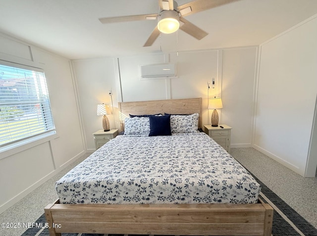 bedroom featuring a ceiling fan, an AC wall unit, a decorative wall, and baseboards