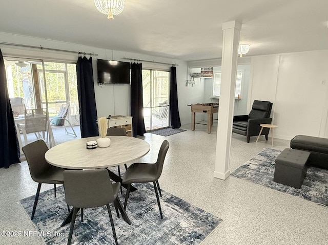 dining room with plenty of natural light, decorative columns, and speckled floor