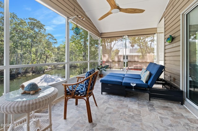 sunroom / solarium featuring lofted ceiling, a healthy amount of sunlight, and a ceiling fan