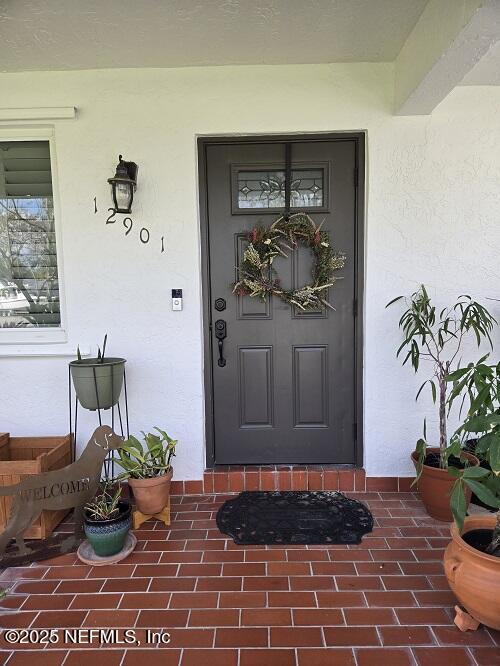 doorway to property with stucco siding