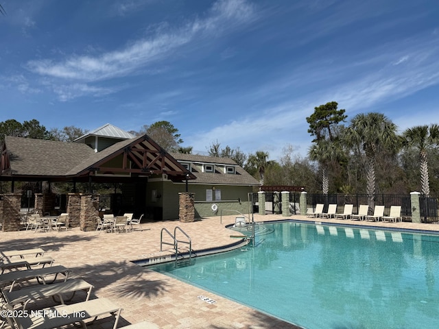 pool featuring fence and a patio