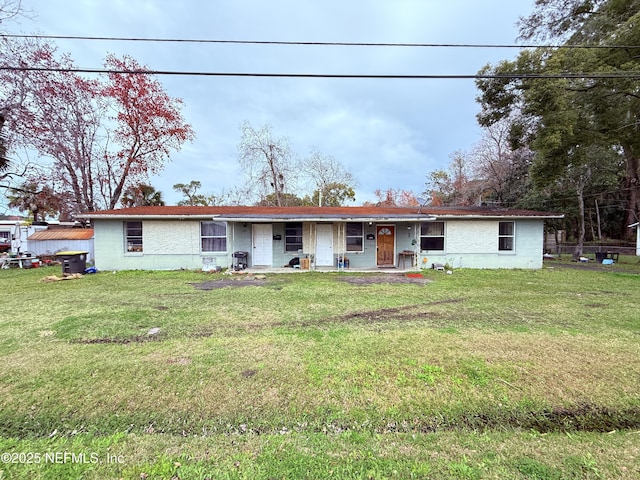 single story home with a front lawn and concrete block siding