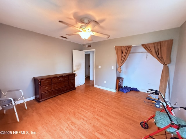 unfurnished bedroom with light wood finished floors, visible vents, baseboards, and a ceiling fan