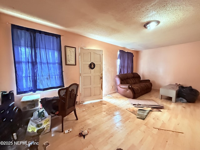 interior space with a textured ceiling and wood finished floors