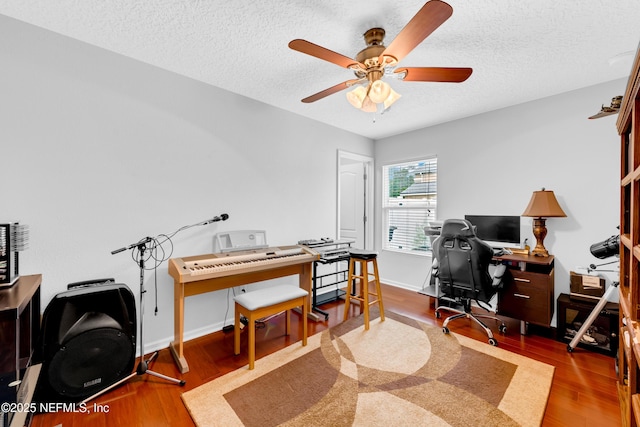 home office with a ceiling fan, a textured ceiling, and wood finished floors