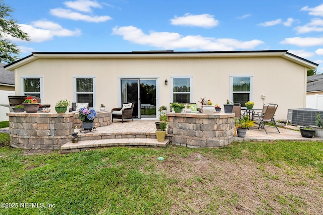 rear view of property with a patio, a lawn, stucco siding, and cooling unit