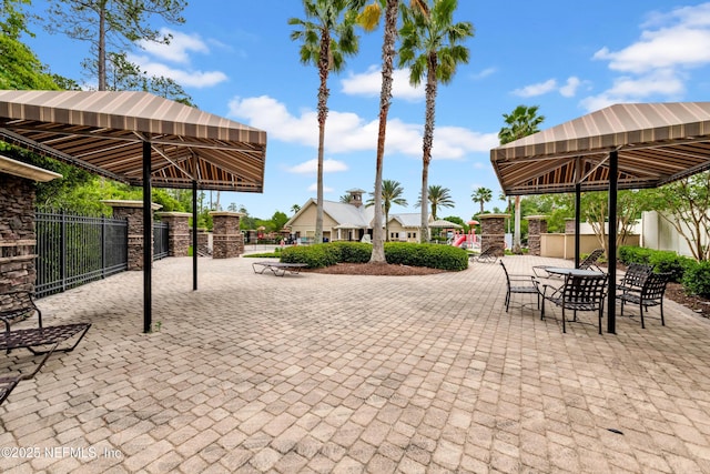 view of patio featuring a gazebo, fence, and outdoor dining space