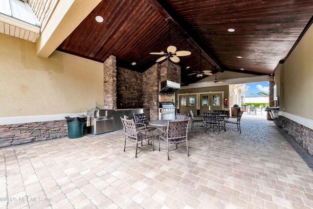 view of patio / terrace featuring exterior kitchen, a ceiling fan, outdoor dining area, and a grill