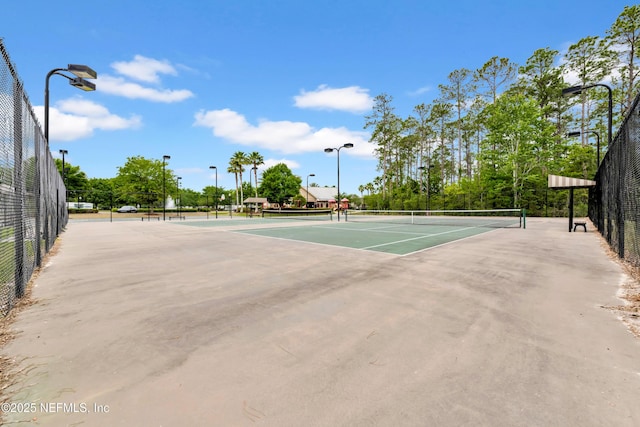 view of tennis court featuring fence