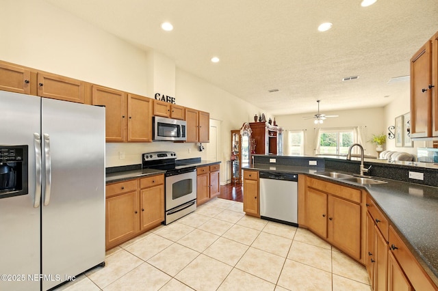 4023 Trail Ridge Rd, Middleburg, FL 32068 - kitchen featuring stainless steel appliances, a sink, dark countertops, brown cabinetry, and recessed lighting
