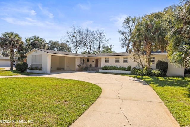 ranch-style house featuring a carport, concrete driveway, and a front lawn