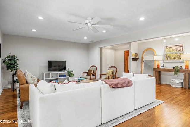 living room with wood finished floors, a ceiling fan, and recessed lighting