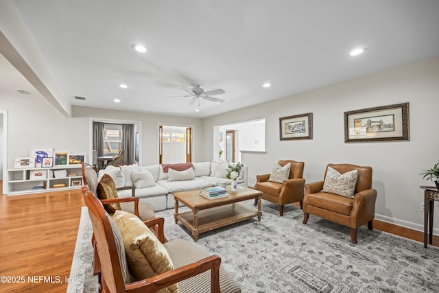 living area with visible vents, light wood-style flooring, and recessed lighting