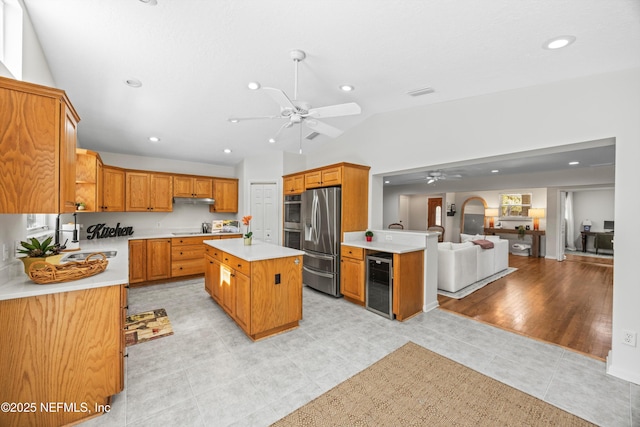 kitchen featuring wine cooler, appliances with stainless steel finishes, a ceiling fan, open floor plan, and a sink