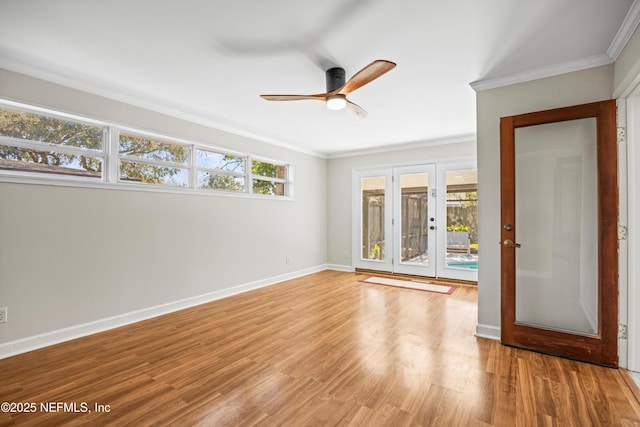 empty room featuring baseboards, french doors, wood finished floors, and a healthy amount of sunlight