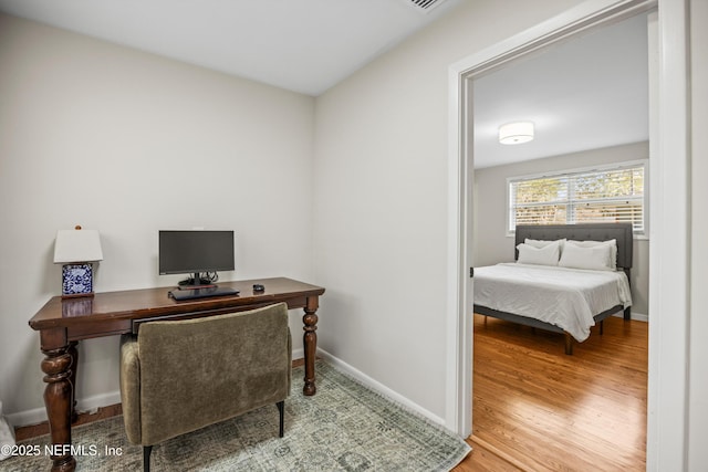 office area with baseboards and wood finished floors