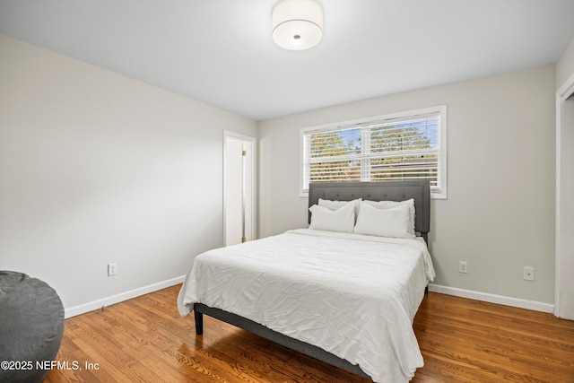 bedroom featuring baseboards and wood finished floors