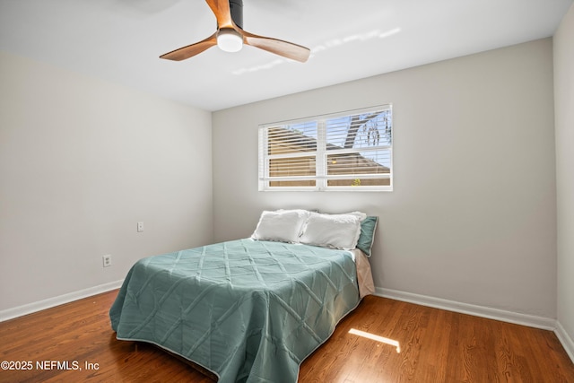 bedroom featuring a ceiling fan, baseboards, and wood finished floors