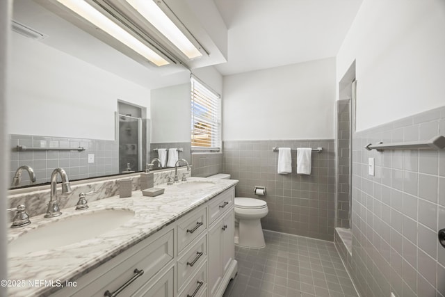 full bath with toilet, a stall shower, a sink, and tile patterned floors