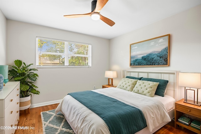 bedroom with wood finished floors, a ceiling fan, and baseboards