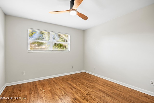 empty room featuring a ceiling fan, baseboards, and wood finished floors