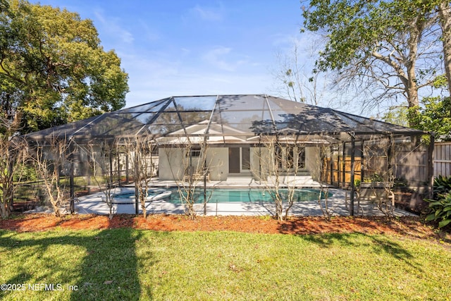 view of swimming pool with a pool with connected hot tub, glass enclosure, a yard, and a patio