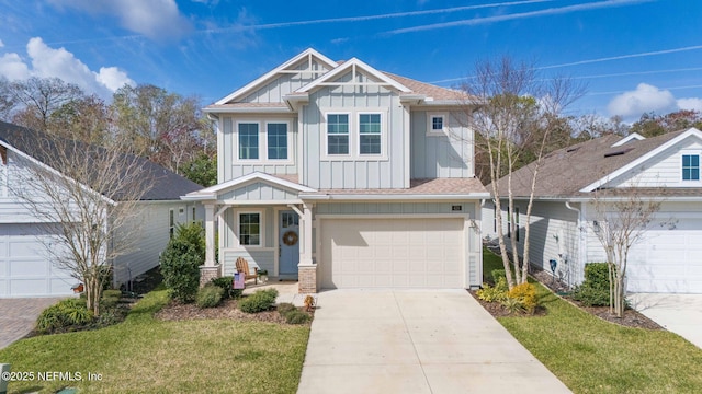 craftsman-style home featuring driveway, a garage, a shingled roof, a front lawn, and board and batten siding