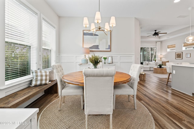 dining space featuring plenty of natural light, a decorative wall, and wood finished floors