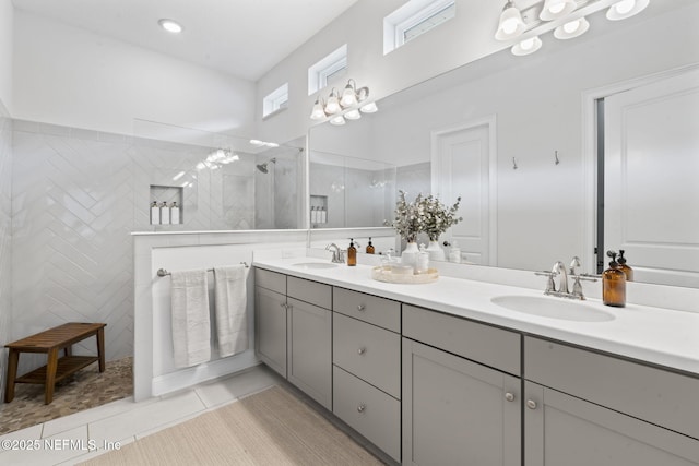 full bathroom featuring double vanity, tile patterned flooring, walk in shower, and a sink