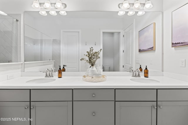 bathroom featuring double vanity, a shower, a sink, and toilet