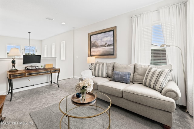 living area with carpet floors, visible vents, and baseboards