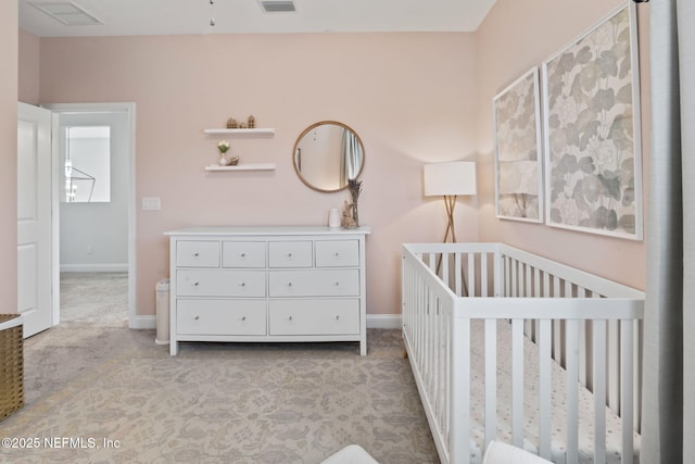 bedroom featuring light carpet, a crib, visible vents, and baseboards