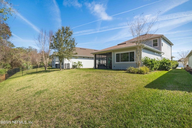 back of property featuring a lawn, fence, and a sunroom