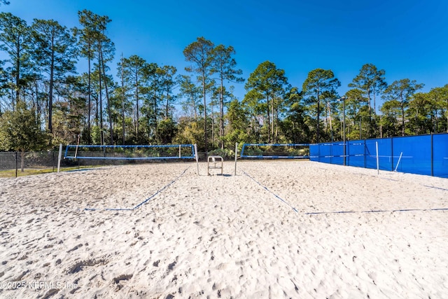 view of home's community with fence and volleyball court