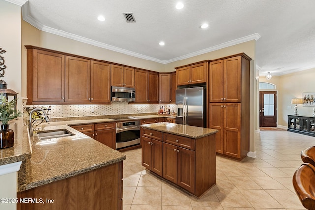 kitchen with light tile patterned flooring, stainless steel appliances, a sink, visible vents, and dark stone countertops